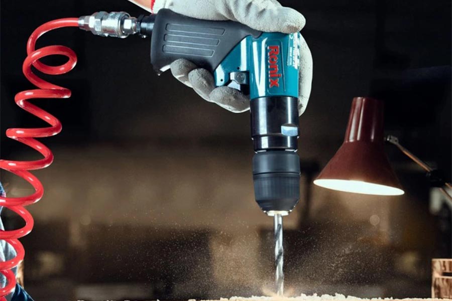 دریل بادی در حال سوراخ‌کاری فلز در محیط کارگاهی